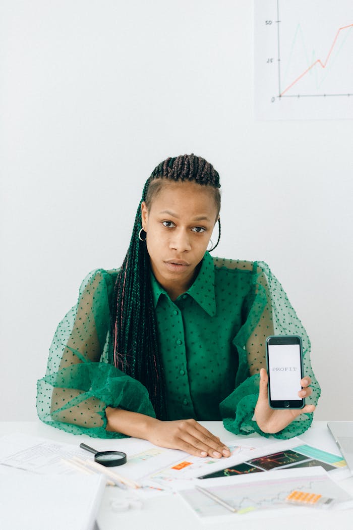 Woman in Green and White Floral Long Sleeve Shirt Holding White Iphone 4